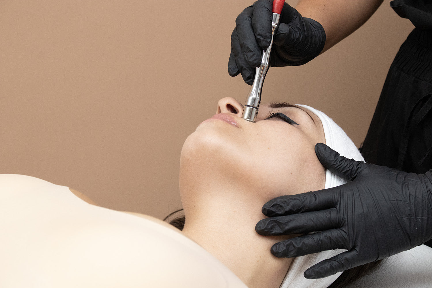 A woman receiving a cosmetic treatment on her face.