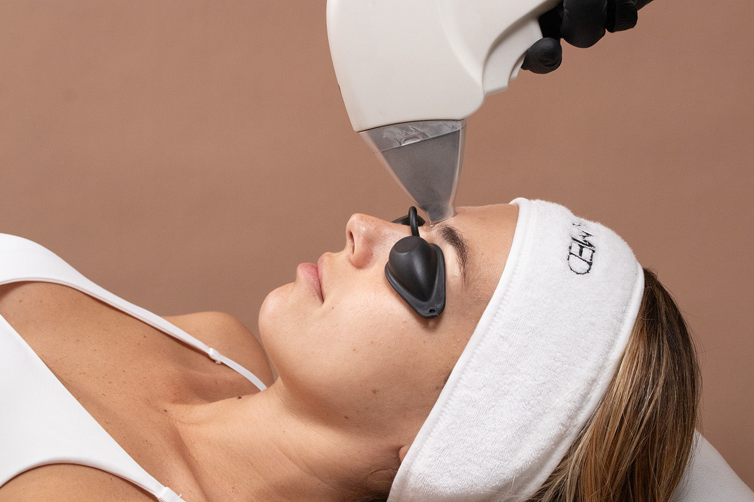 A woman receiving laser hair removal on her face.