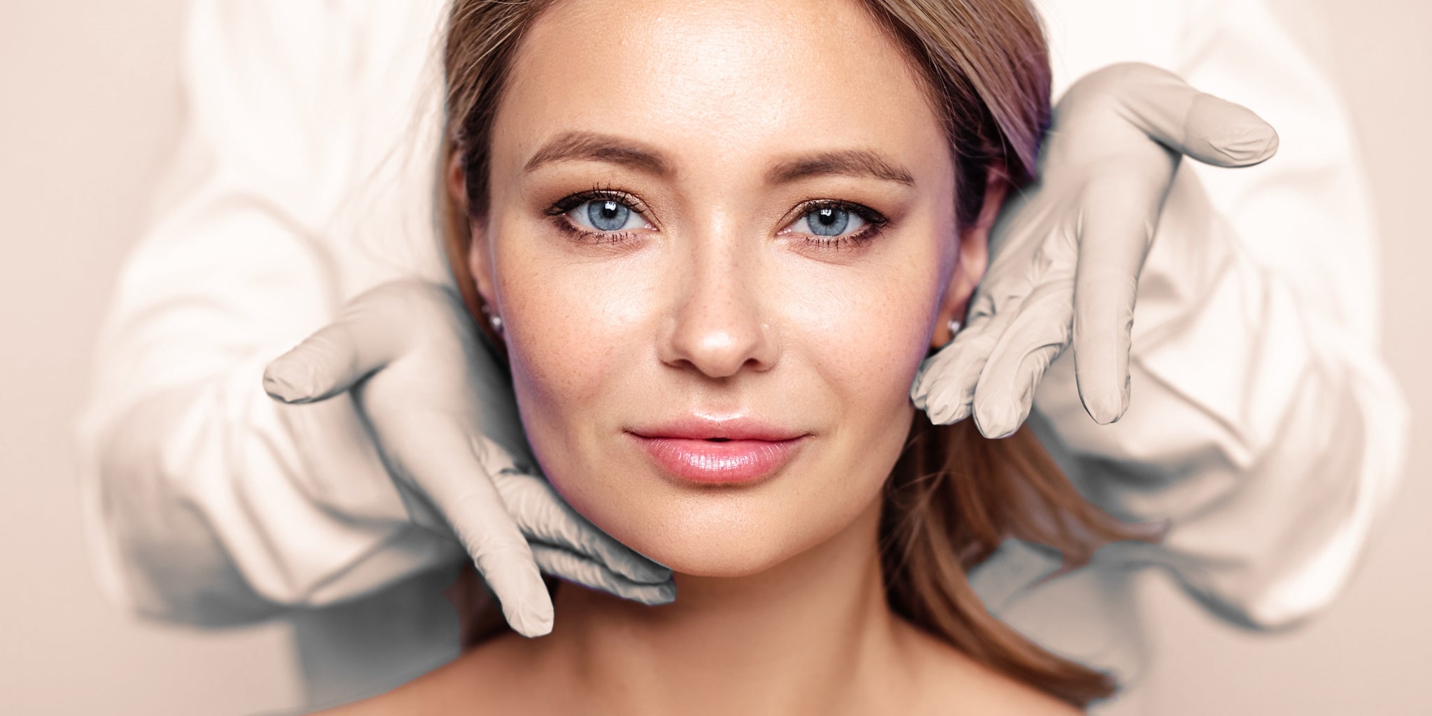 A woman looking at the camera while a pair of gloved hands hold her face.