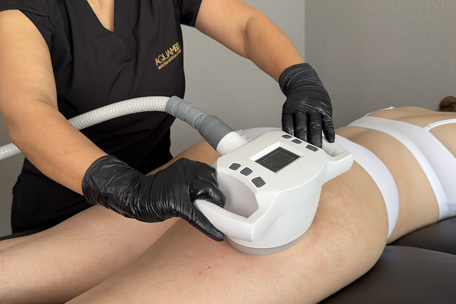 A woman receiving a cosmetic treatment on her thighs.