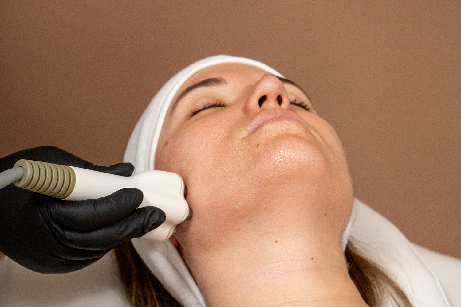A woman receiving a cosmetic treatment on her face.