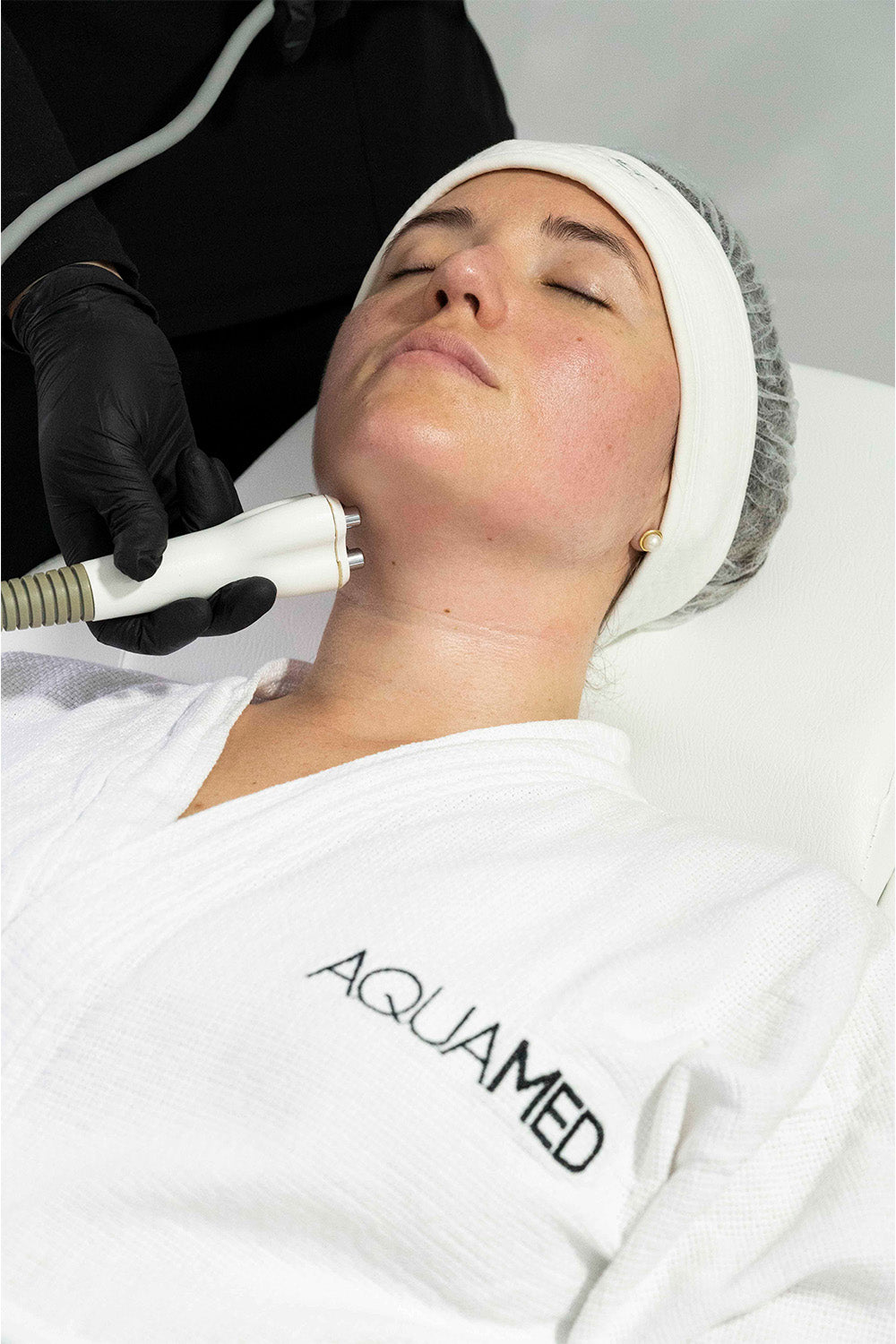 A woman receiving a cosmetic treatment on her face. 