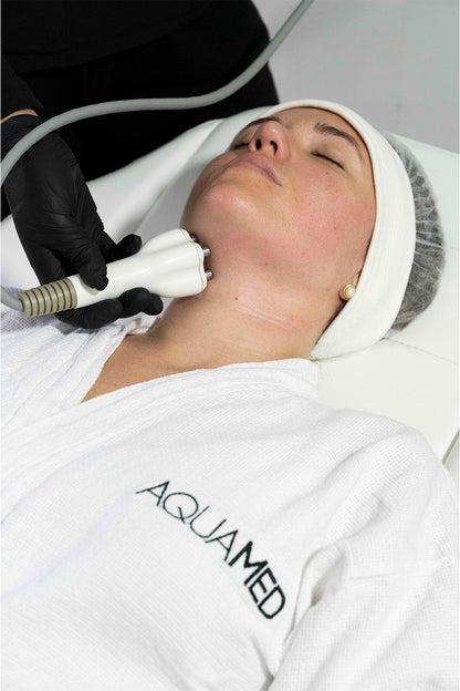 A woman receiving a cosmetic treatment on her face. 